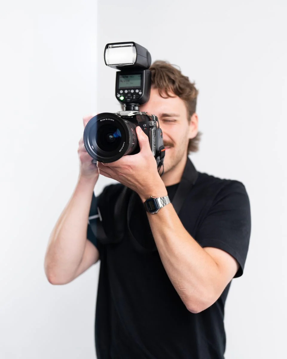 Photographer raising a camera with a flash mounted on top