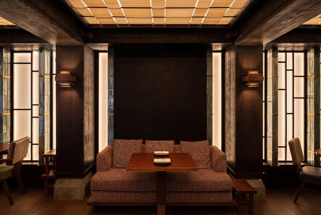 Dark timber restaurant booth with backlit lattice ceiling