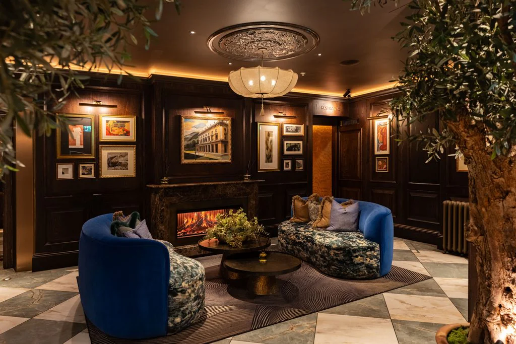 Lounge with fireplace, chandelier and blue velvet armchairs