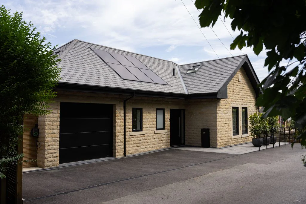 Stone bungalow exterior with slate roof and double garage