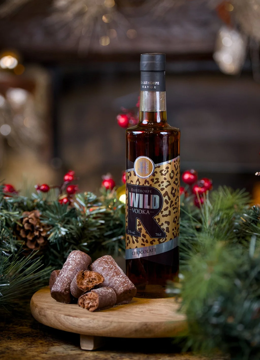 Bottle of vodka on a wooden board with pine and a lit fire behind