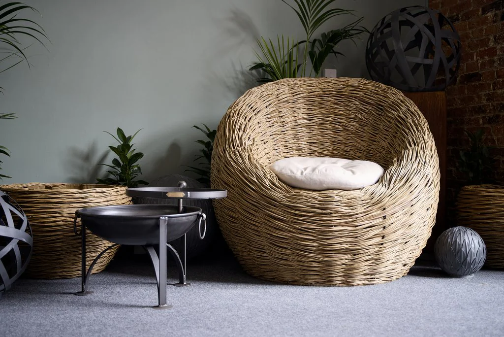 Woven garden chair and fire bowl in a showroom setting