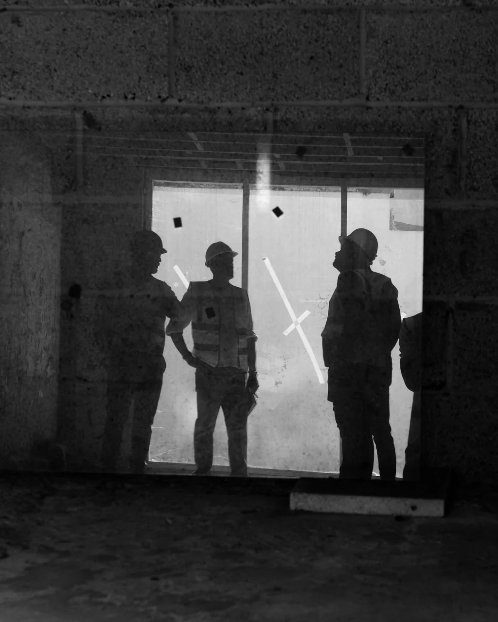 Silhouetted construction workers on site, black and white