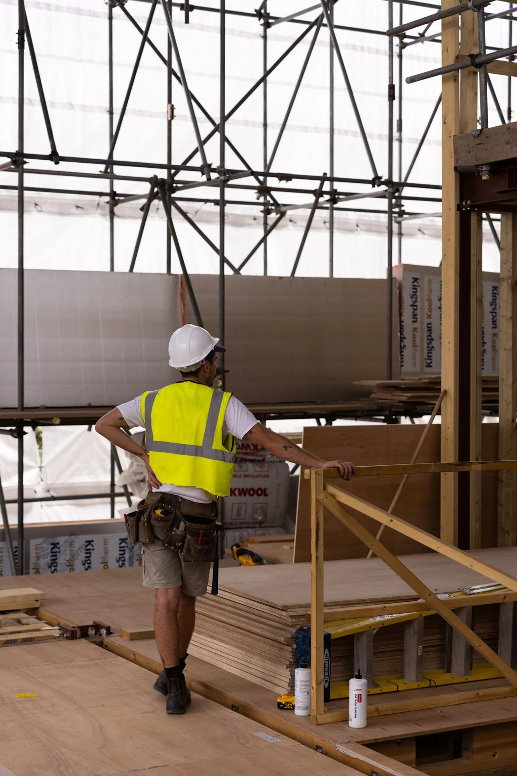 Construction worker inside a scaffolded timber frame