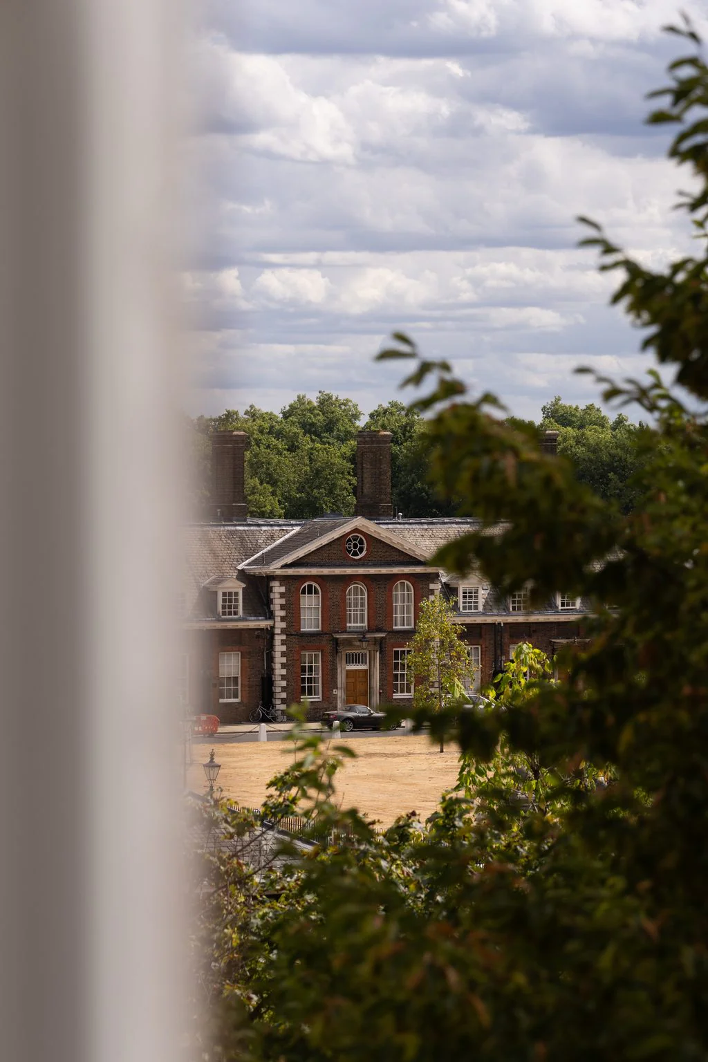 Red-brick building seen through trees