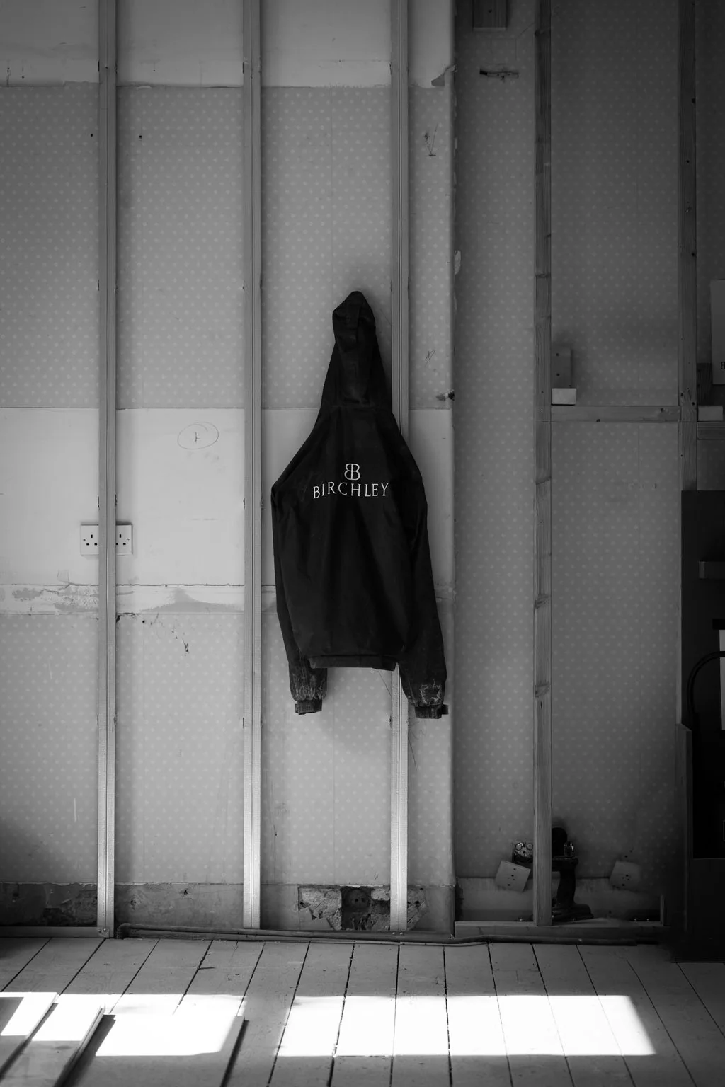 Hoodie hanging in an unfinished room lit by sunlight