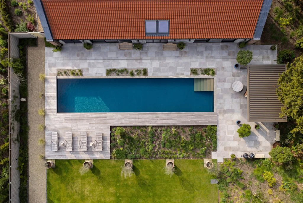 Aerial view of a pool house and swimming pool, filmed by drone