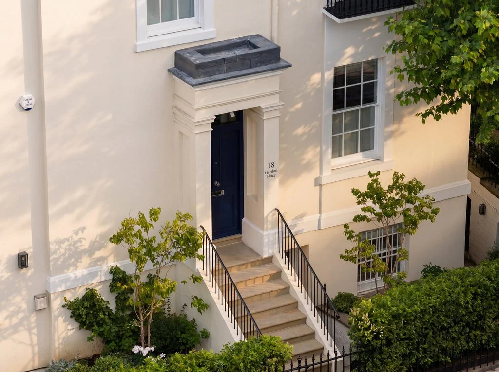 Cream townhouse entrance with steps and iron railings