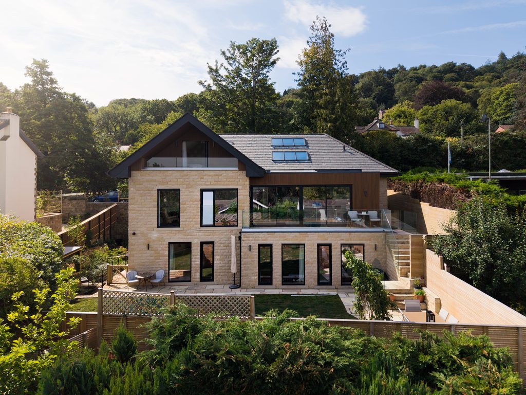 Aerial view of a stone house with terrace among trees