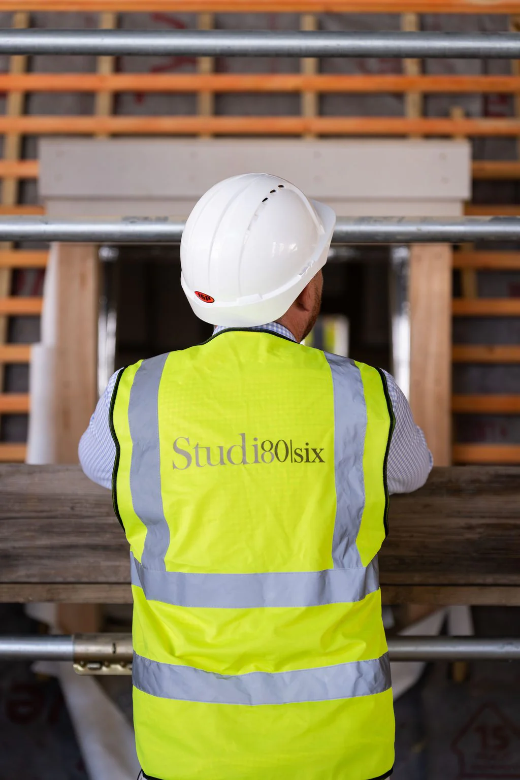 Site worker in hi-vis on scaffolding, the kind of photo that gets seen on LinkedIn
