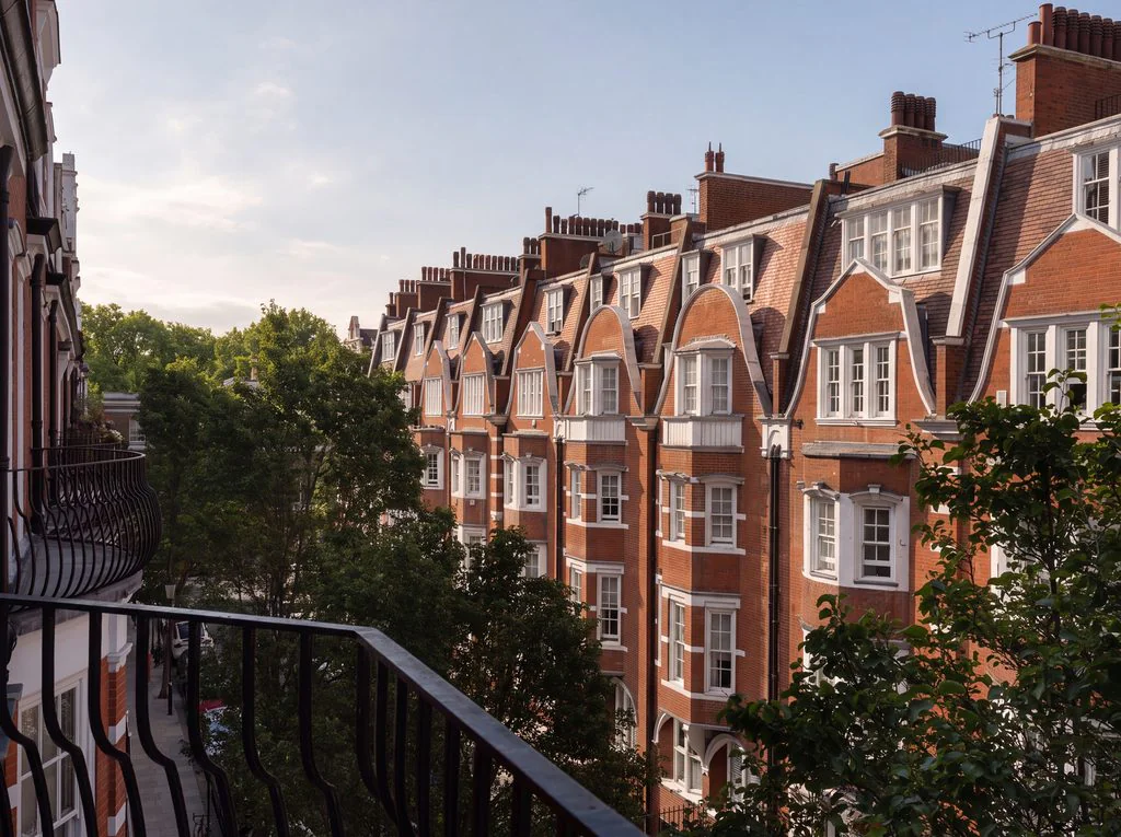 Red-brick mansion block with balconies at golden hour