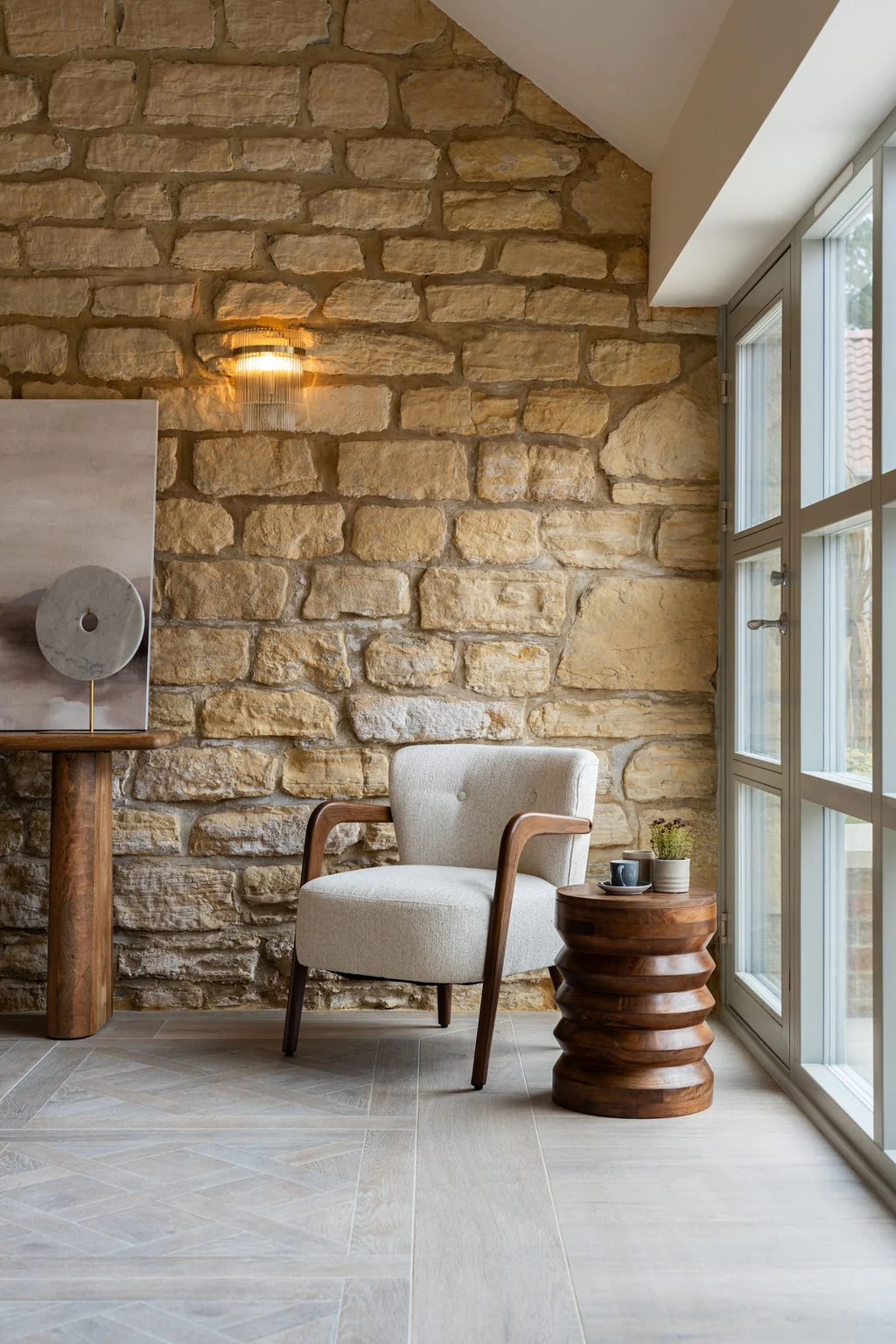 Armchair against an exposed stone wall with skylight