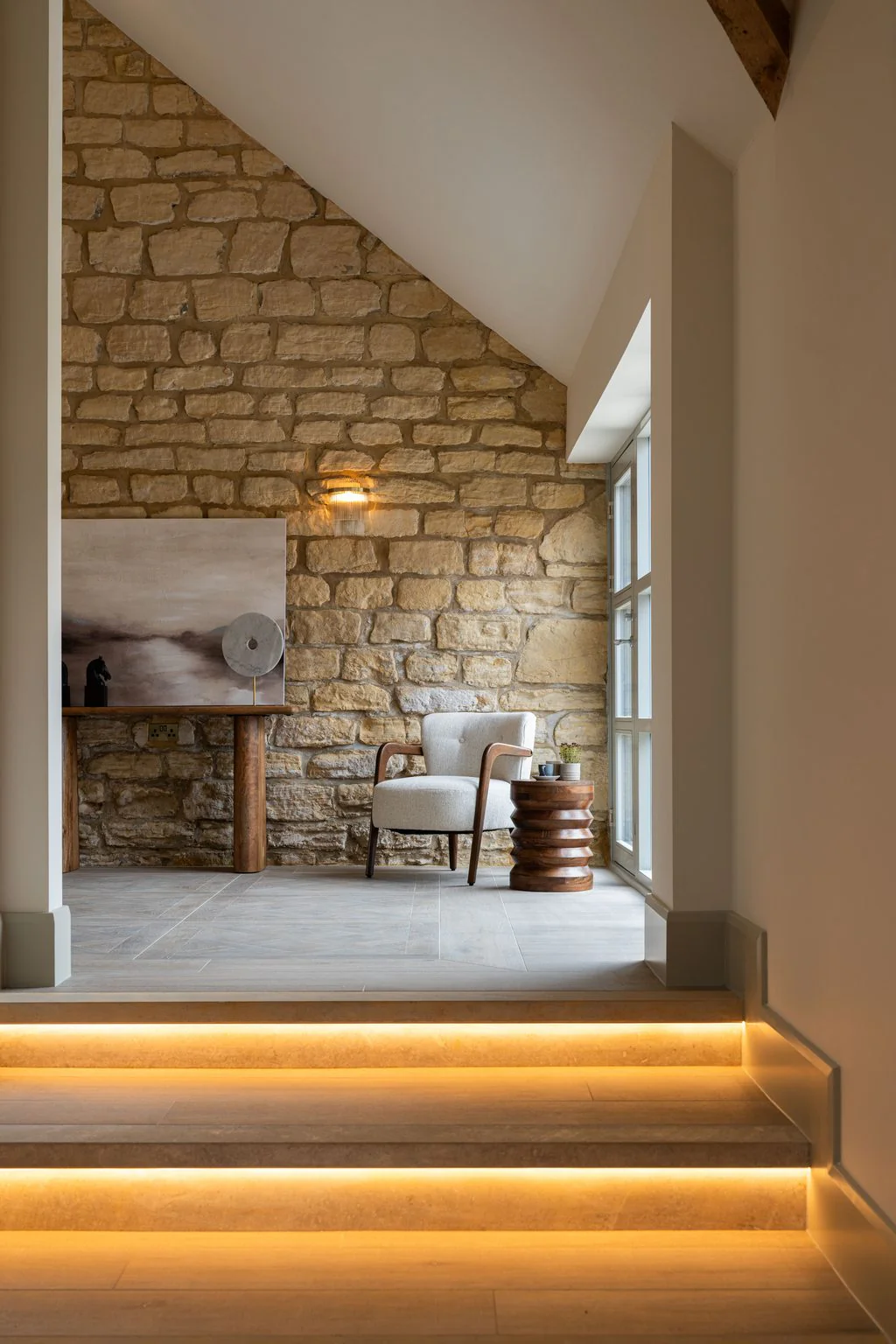 Stone-walled room with lit steps and armchair
