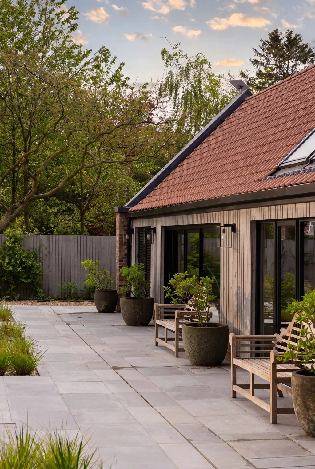 Terracotta-roofed house with terrace and planting