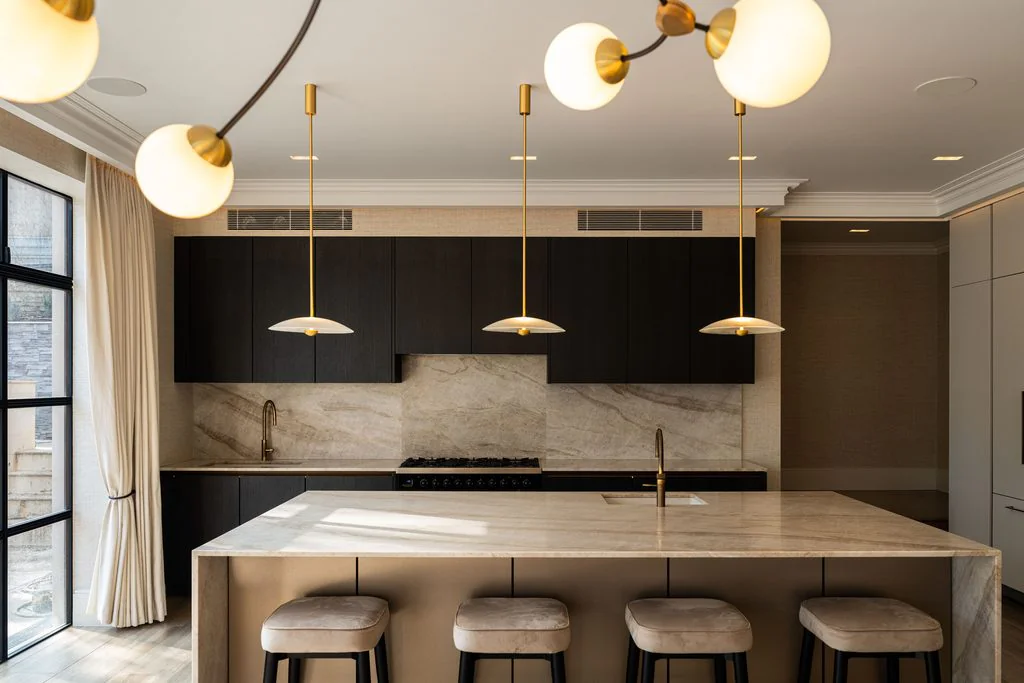 Kitchen with marble island and globe pendant lights