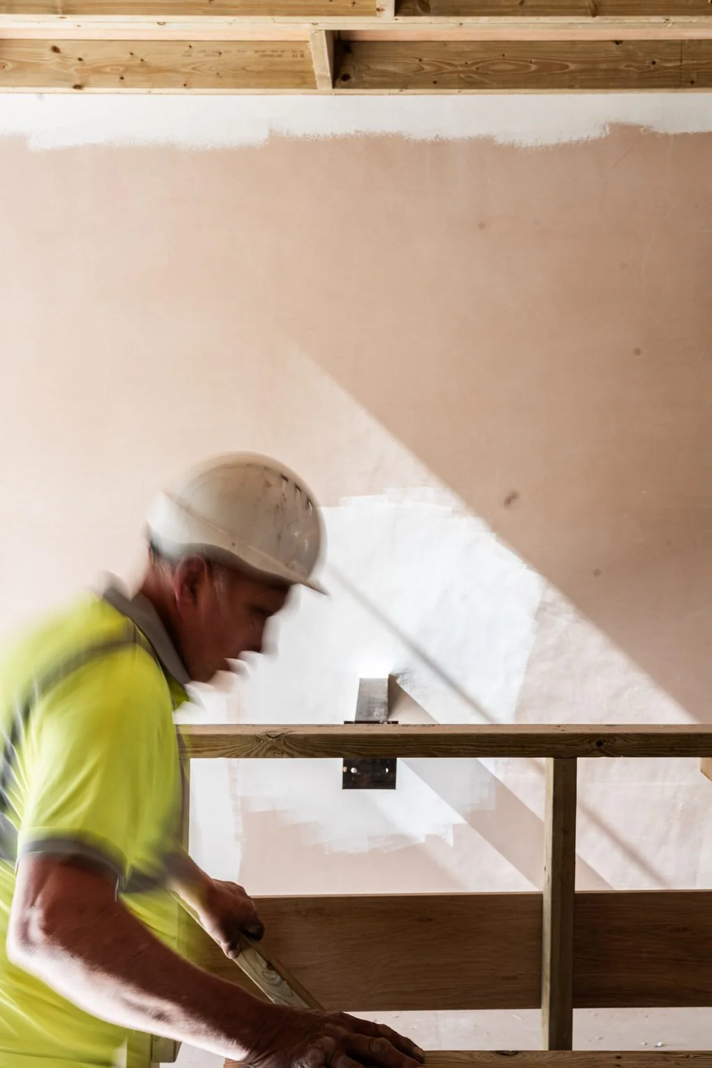 Plasterer at work on a new wall, a finished job photographed as it happens