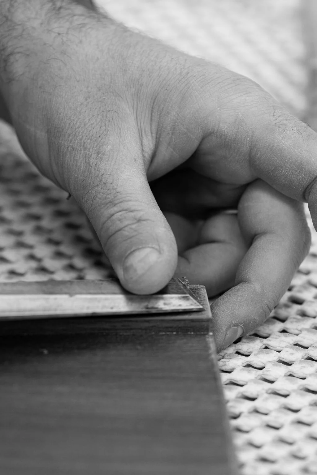 Hand on perforated steel, black and white