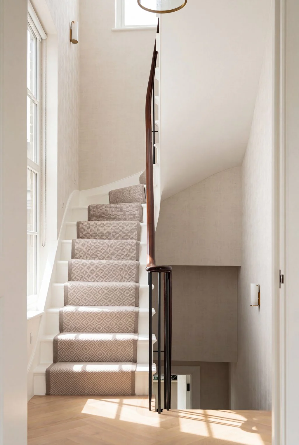 Carpeted staircase lit by a skylight